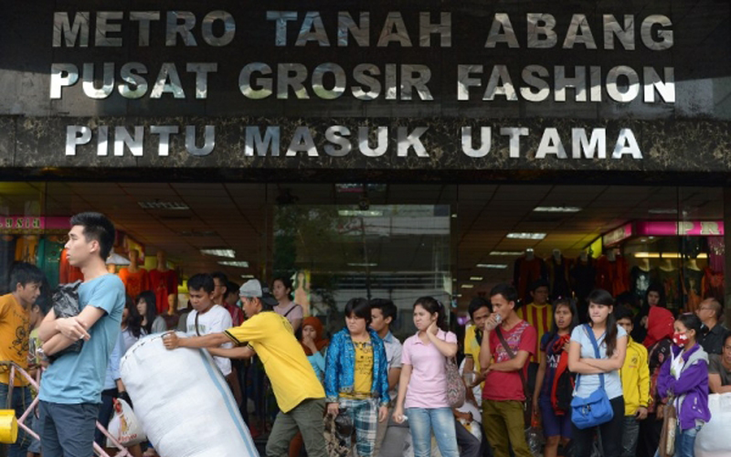 This picture taken in Jakarta on October 29, 2013 shows people waiting outside the Tanah Abang textile market in Jakarta. (Pic credit: AFP) 