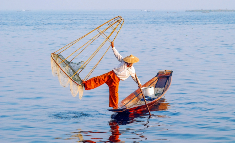 A fisherman at Inle Lake performing his daily balancing act while fishing. (Photo Credit: Traveloka)