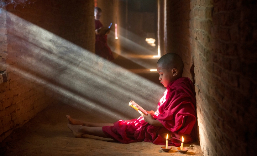 Young monk reading in Bagan, Myanmar (Photo Credit: Flickr / John Lyon)