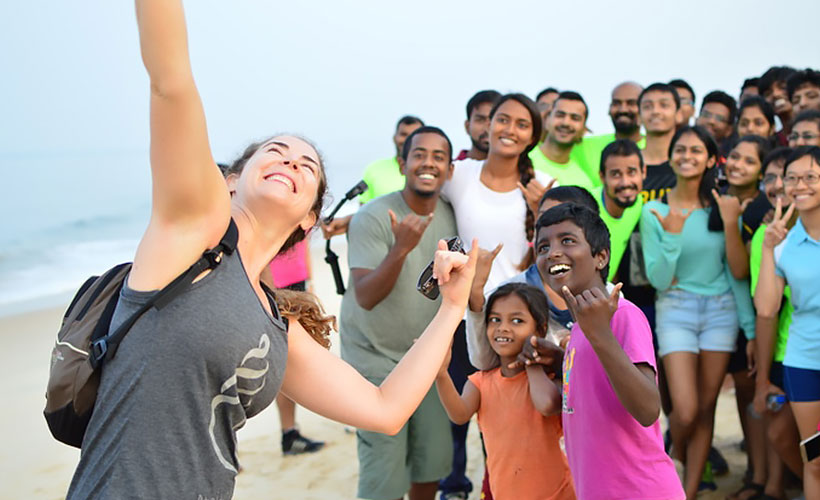 Claire getting to know some new friends in India before running together along the sandy shoreline. (Photo Credit: Claire MacFarlene)