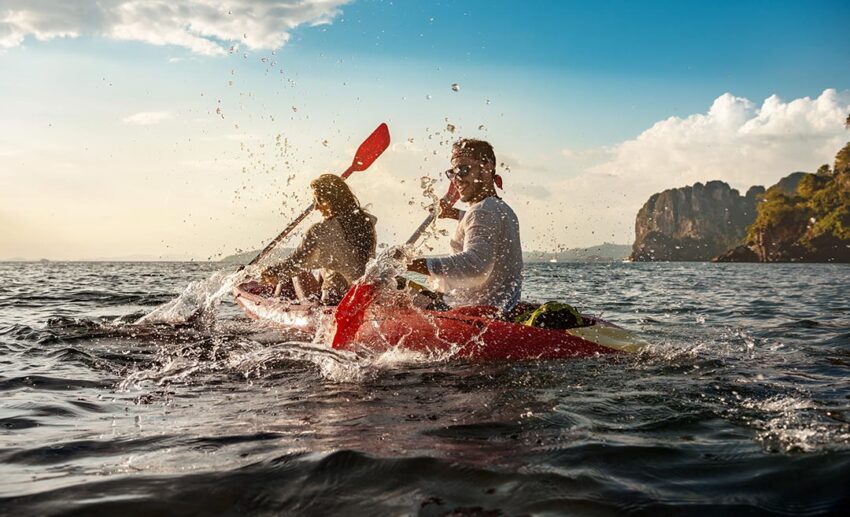 A couple kayaking on calm water during a lightly active afternoon excursion.