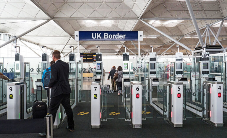 International traveller at a UK border control desk during the implementation of the new UK ETA rules.