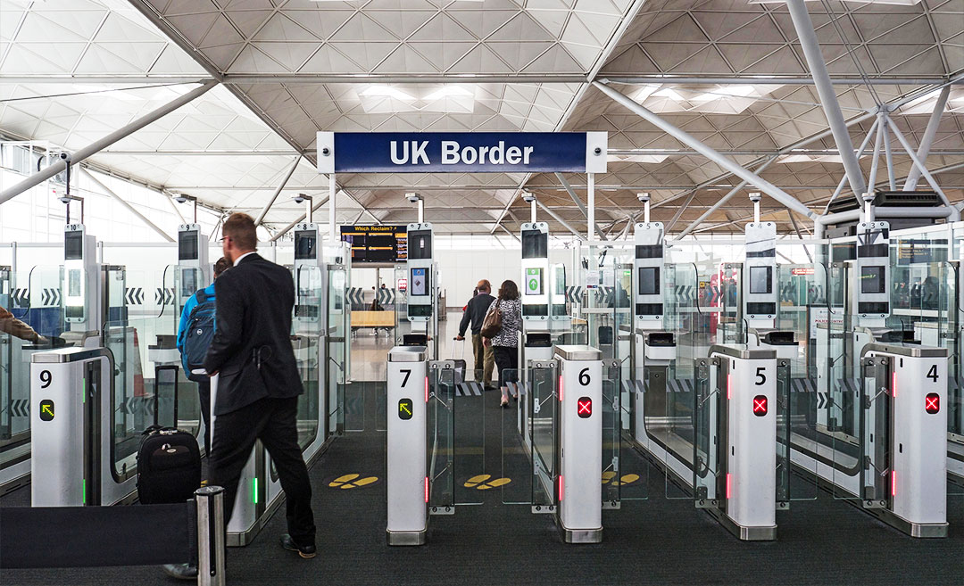 International traveller at a UK border control desk during the implementation of the new UK ETA rules.