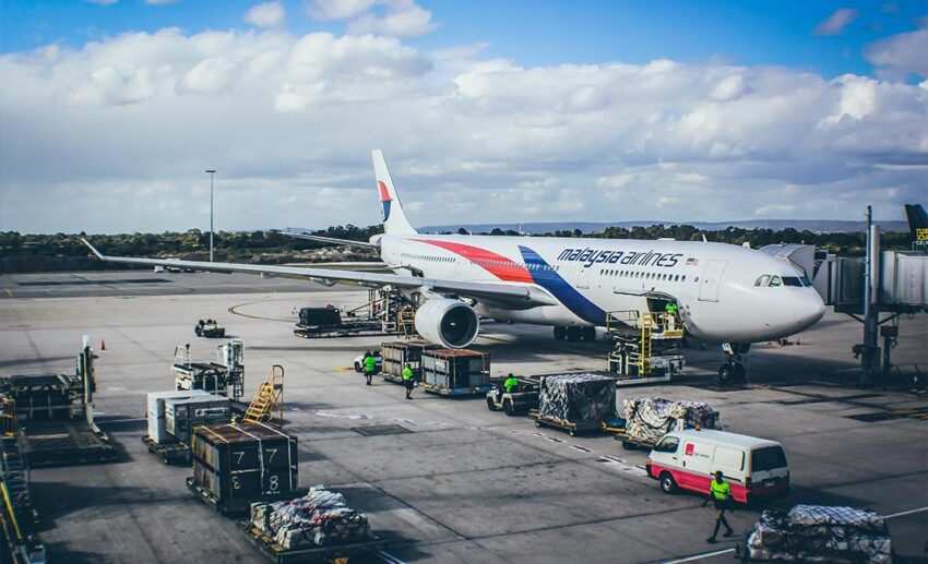 A Malaysia Airlines wide-body jetliner parked on the airport tarmac, ready for a long-haul flight.