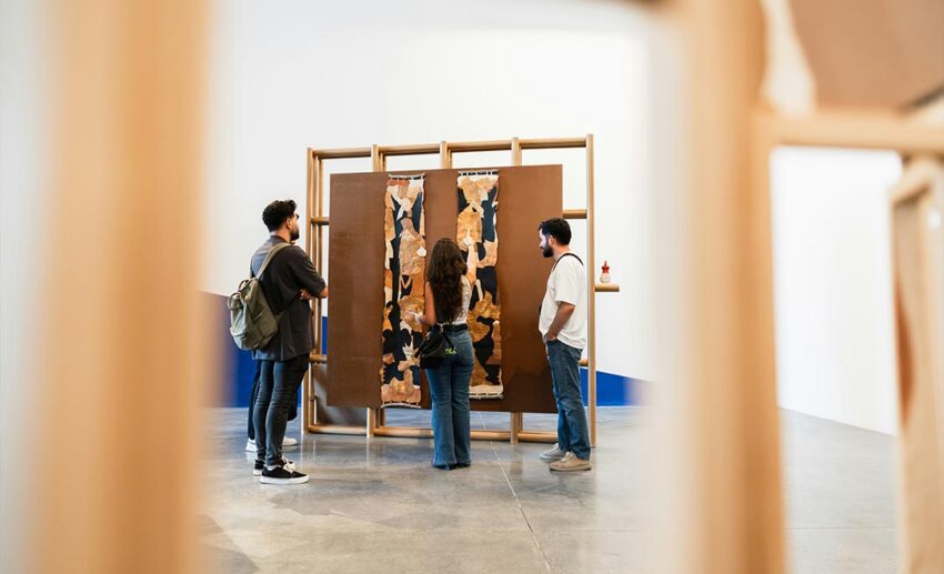 Three colleagues viewing a modern art installation at a gallery during a low-stakes city day trip.