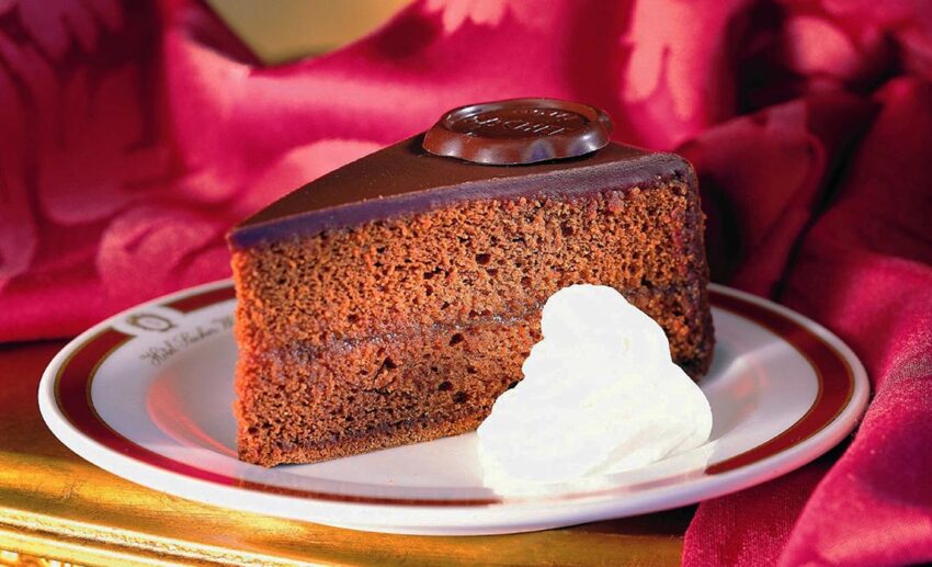 The original Sachertorte dark chocolate cake with apricot jam, served with whipped cream at the Hotel Sacher in Vienna.