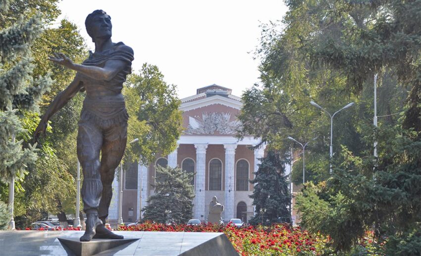 A decorative statue and historic building in the city of Bishkek, reflecting the unique urban culture of Kyrgyzstan.
