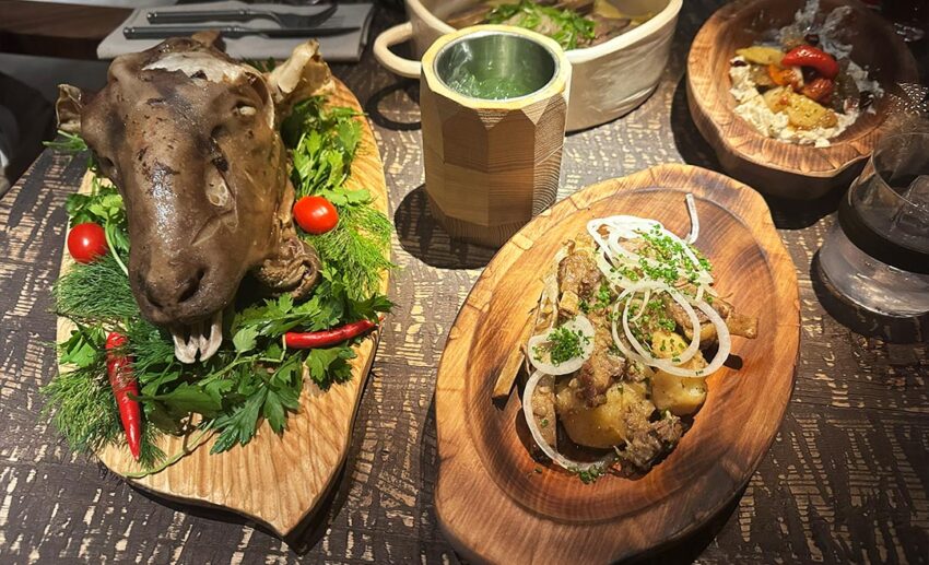 A traditional Kazakh dish featuring a sheep's head served on a large platter at Yurta restaurant in Almaty.