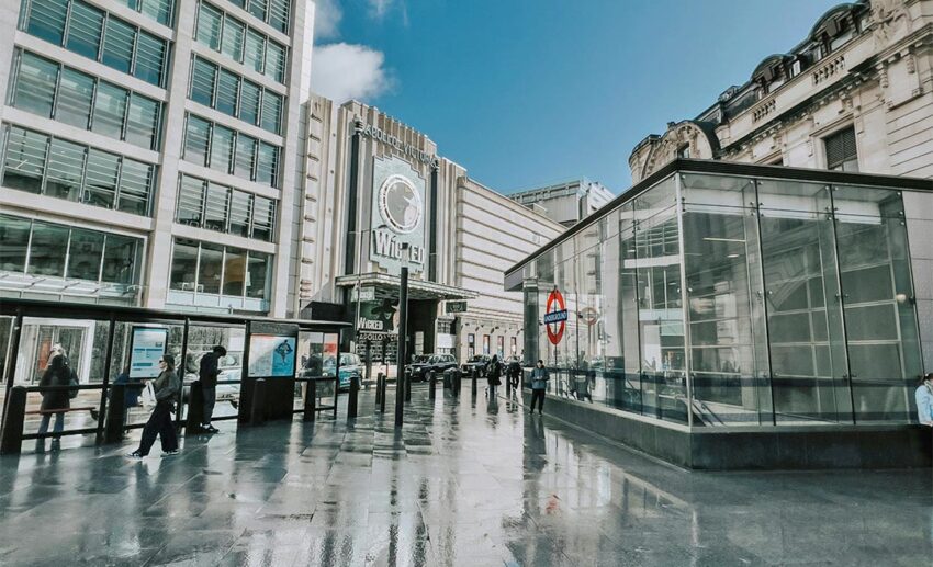 A classic London cityscape featuring modern buildings, wet streets, and reflections of the city skyline in the United Kingdom.