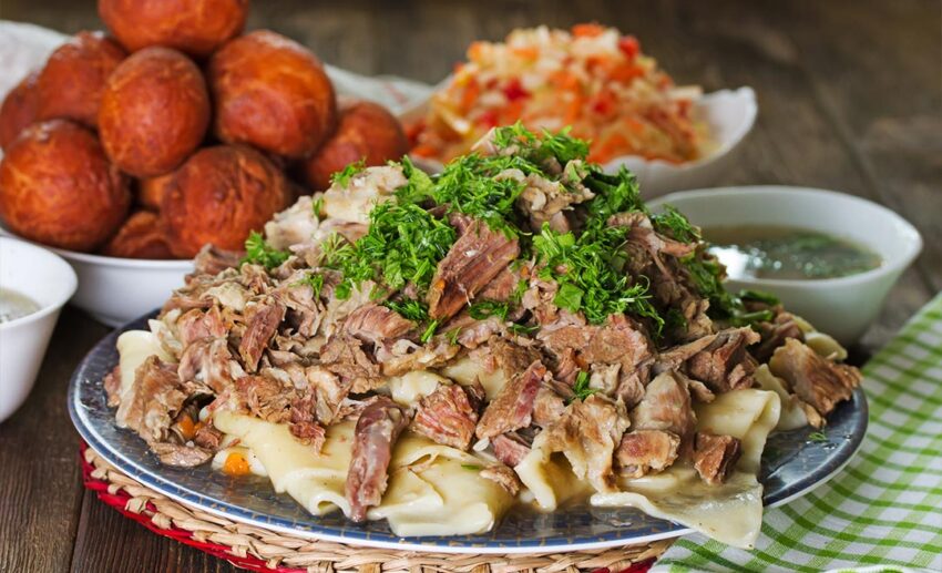 Traditional Central Asian dishes including Beshbarmak (meat and noodles), Shalgam radish salad, and Baursak fried dough.