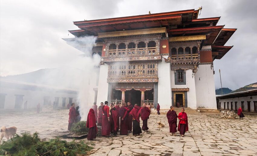 Buddhist monks and young students performing a traditional herb-burning ritual at Gangtey Monastery in Bhutan.