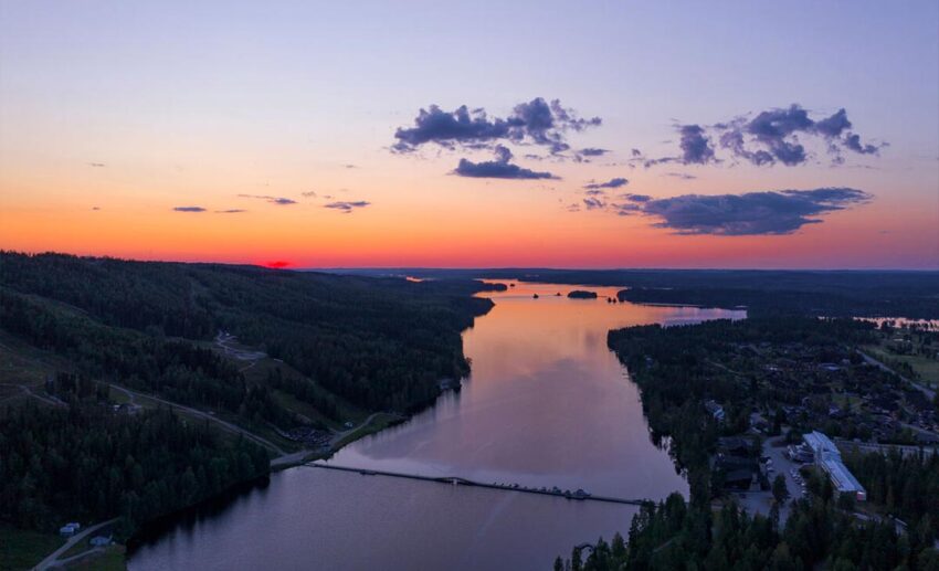 Sunset drone photography of Lake Syväri and the Tahkolahti Bay Bridge in Finland during the golden hour.