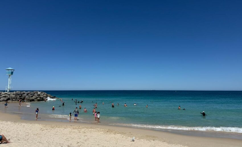 A serene, wide-angle shot of a quiet Western Australian beach with soft light hitting the shoreline.