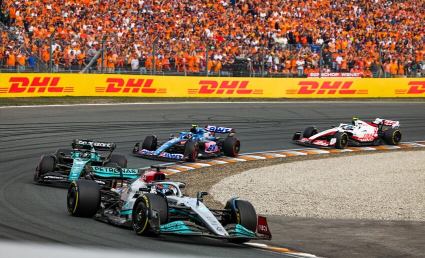 Two Mercedes-AMG Petronas Formula One cars driving back-to-back on the Zandvoort Circuit during a race weekend.