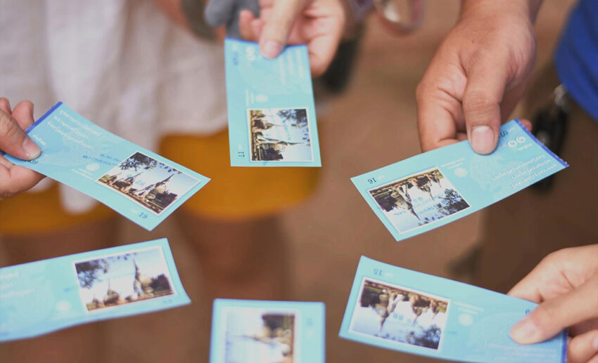 A close-up shot of a group of friends holding up physical event tickets and stubs as travel keepsakes.