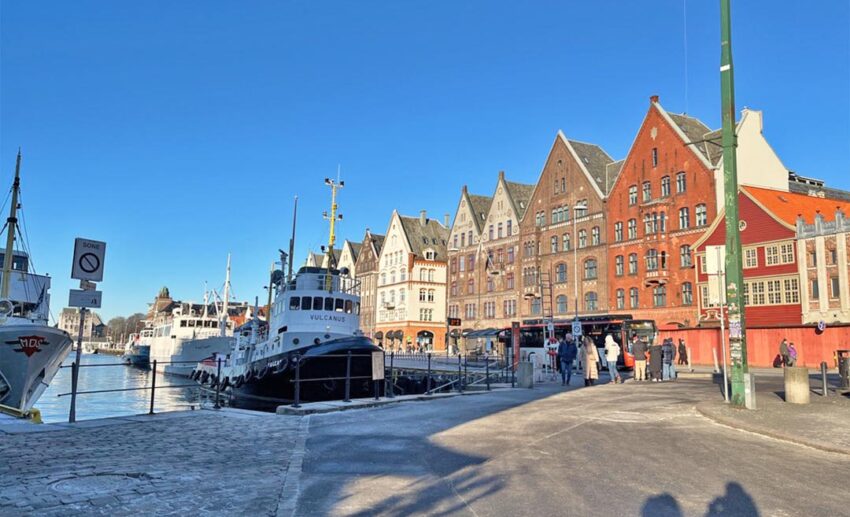 The iconic colourful wooden buildings of the Bryggen Hanseatic Wharf in Bergen, Norway, reflecting the golden light of a winter afternoon.