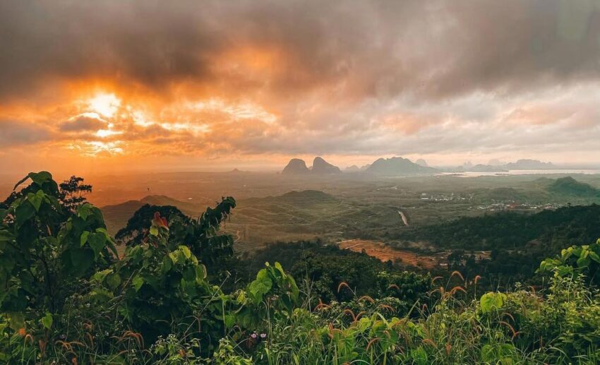 A cloudy morning sunrise view from Wang Kelian viewpoint in Perlis, overlooking the lush greenery and limestone ridges of the Nakawan Range.