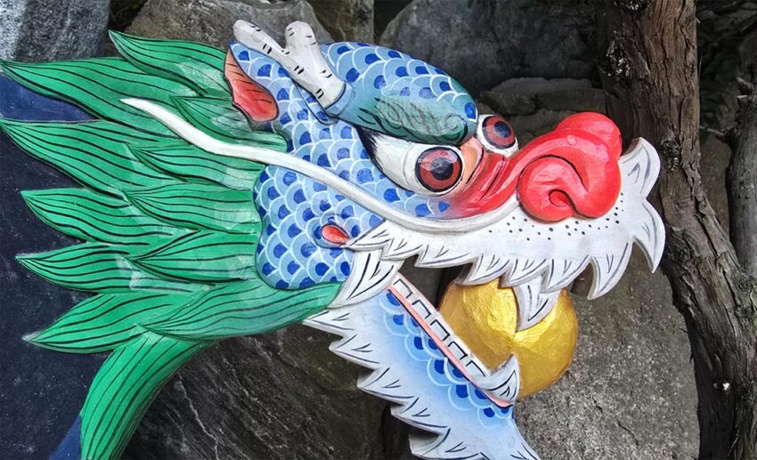 A colourful traditional Korean dragon statue with a gold coin in its mouth at Haedong Yonggungsa Temple, Busan.