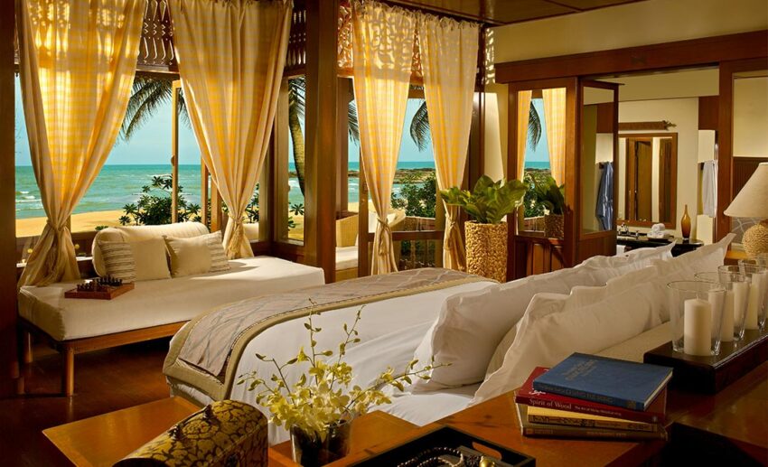 Interior view of the Anjung Room bedroom at Tanjong Jara Resort, featuring traditional Malay timber design and luxury furnishings.