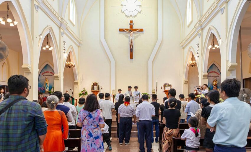 The interior of a church during a mass, showing the congregation and the architectural details of the sacred space.
