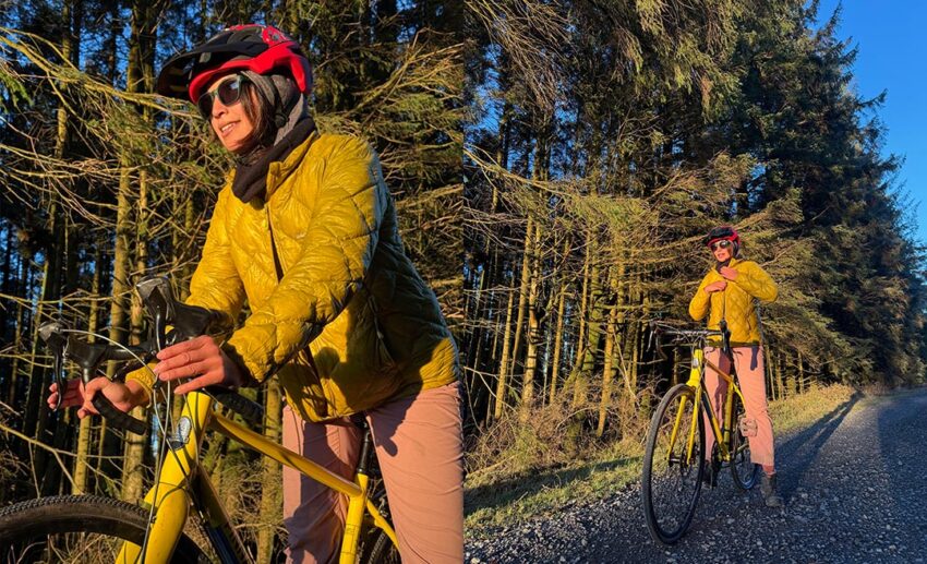 The writer, wearing a yellow puffer jacket and a cycling helmet, prepared for a biking adventure in Grizedale Forest, Lake District.