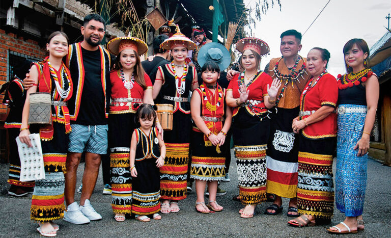 A group of local celebrants standing together during a Gawai open house event in Sarawak, showcasing the communal spirit of the harvest festival.