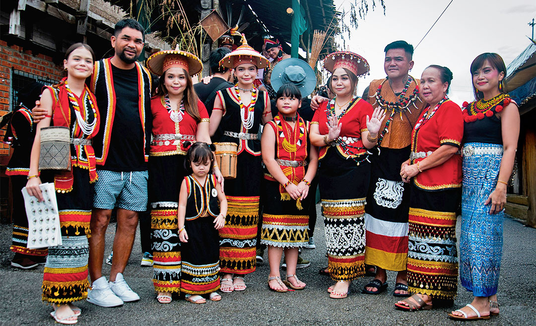 A group of local celebrants standing together during a Gawai open house event in Sarawak, showcasing the communal spirit of the harvest festival.
