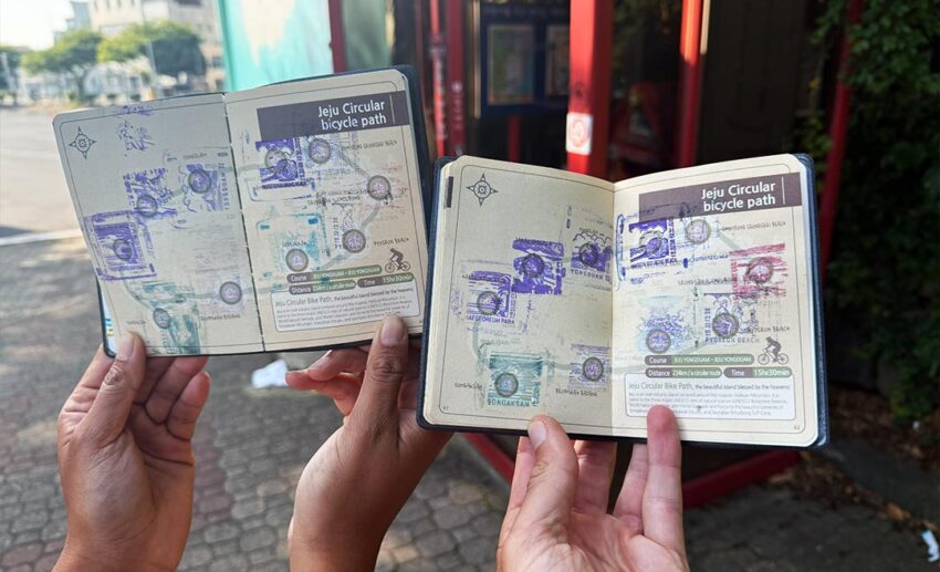 A close-up view of an official South Korean cycling route passport book, showing the final ink certification stamps collected along the Jeju trail.