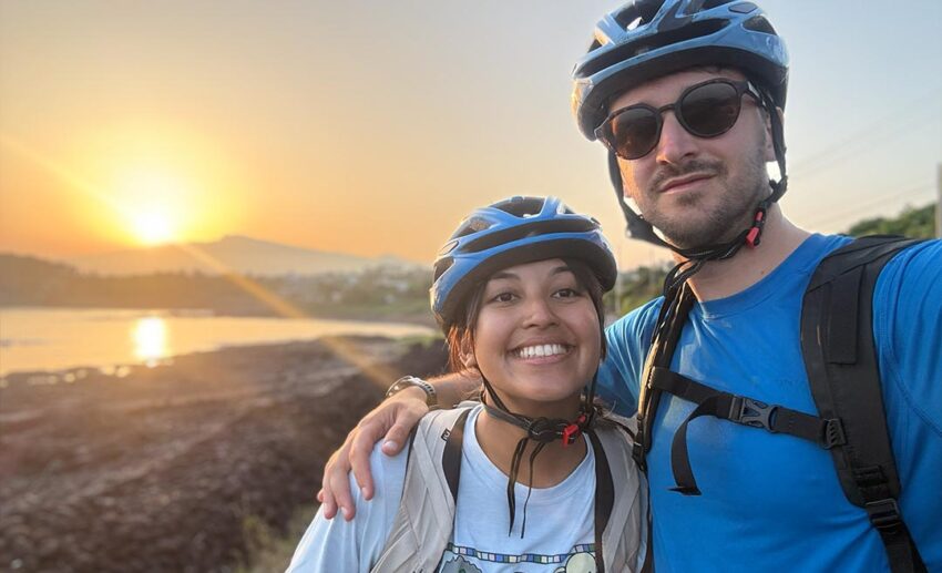 A warm sunset selfie of Sofia Shamsunahar and Johnny Adams posing happily during their long-distance bicycle journey around Jeju Island.