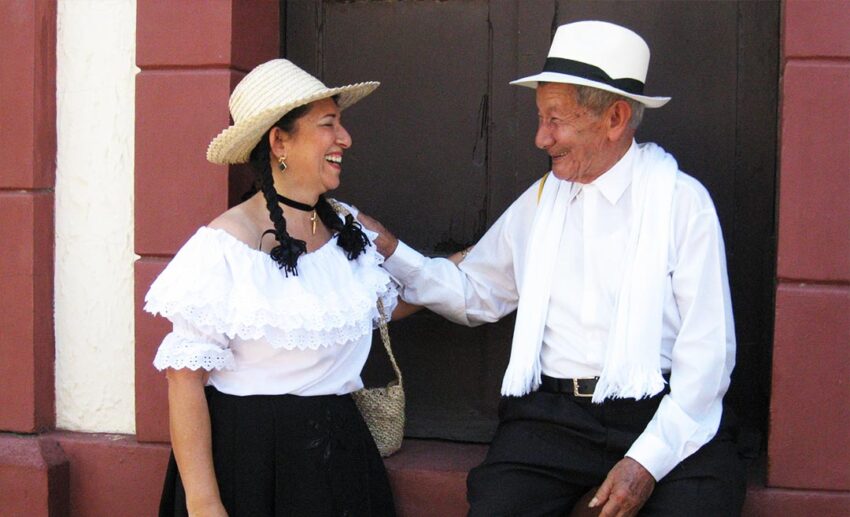 Elderly local couple smiling in traditional clothing in Socorro Santander Colombia illustrating authentic cultural travel experiences