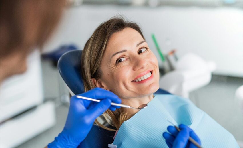 A female patient receiving a routine dental check-up from a professional dentist in a modern clinical surgery.