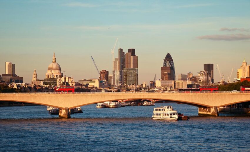 Scenic sunset view of the iconic City of London skyline and Westminster buildings captured across the River Thames.