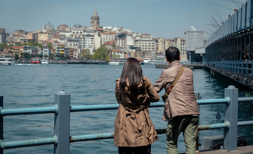 Multigenerational travellers looking out at the Istanbul skyline Galata Tower and Bosphorus Strait on a milestone birthday trip