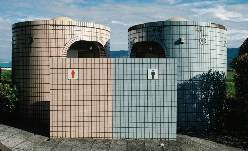 The outdoor entrances of public men and women restrooms located along a travel highway or roadside.