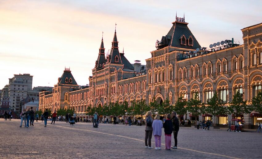 Tourists and visitors gathering in the expansive open space of Red Square in Moscow, Russia, on a bright day.