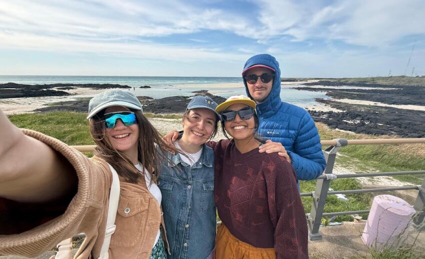 Sofia and her group of friends smiling and posing together on their slow travel trip across Jeju Island.