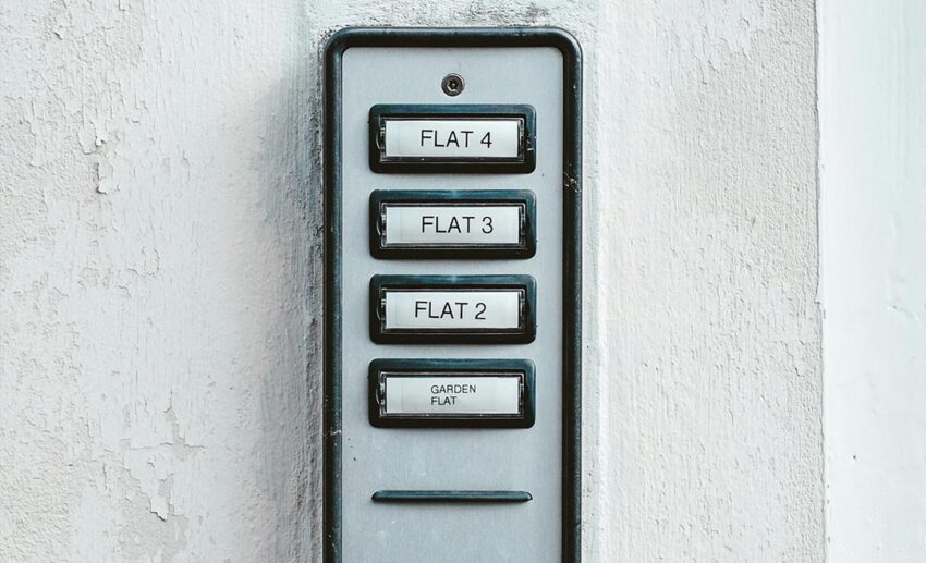 An intercom buzzer panel on the exterior entrance of a residential apartment building