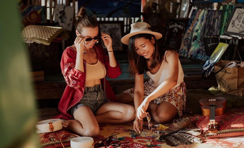Two women sitting comfortably on the floor engaging in a creative craft workshop together