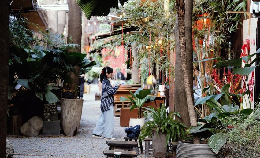 A woman standing in a lush, green al fresco garden terrace of an upmarket venue