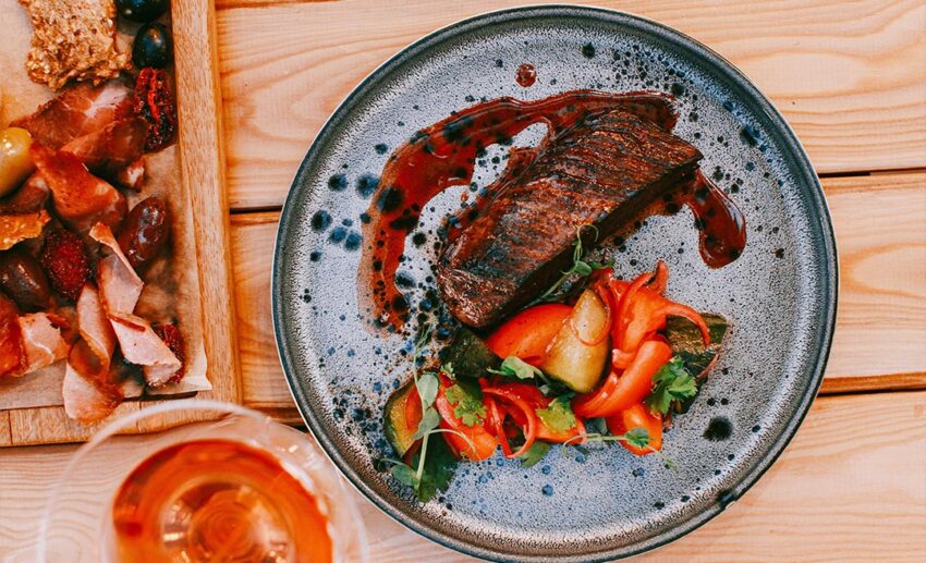 Top-down view of a plated steak meal with fresh colourful vegetables served at a restaurant