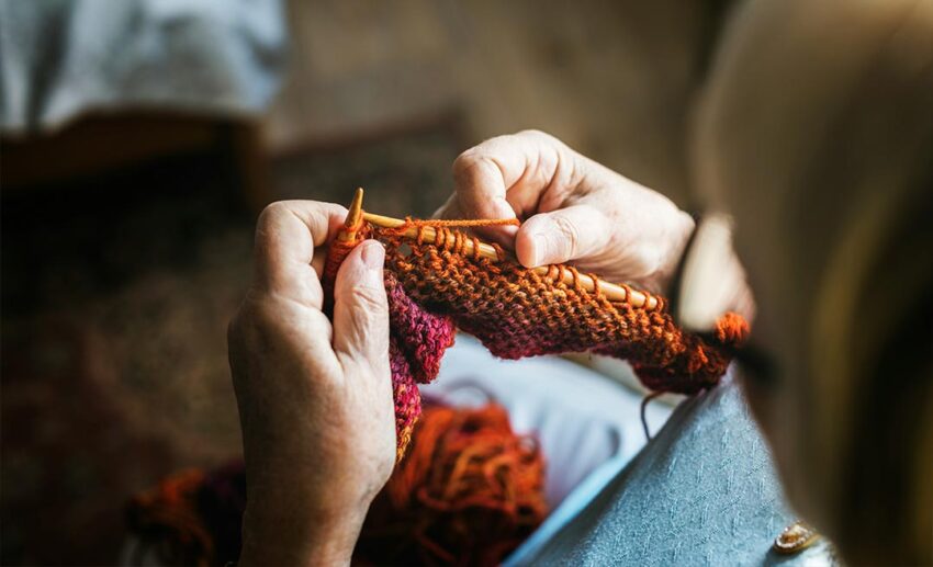 Woman sitting at home knitting a craft project with local yarn