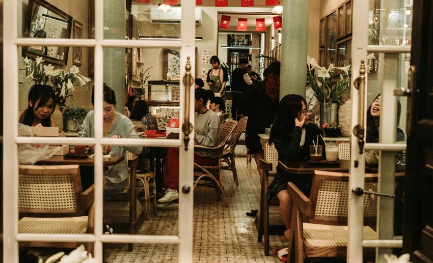 People dining, drinking coffee, and socialising inside a cosy café in Vietnam