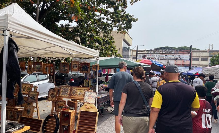 Vendors displaying second-hand trinkets, vintage collectibles, and antiques along the car-free street of Memory Lane Flea Market in Ipoh.