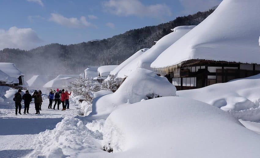 Traditional Japanese multi-course meal, regional sake, and hot spring preparation in snowy Aizu.