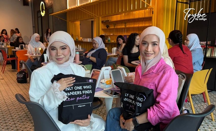 Two female hijab-wearing attendees smiling and posing together with their Embryolisse and Wardah beauty goodie bags.