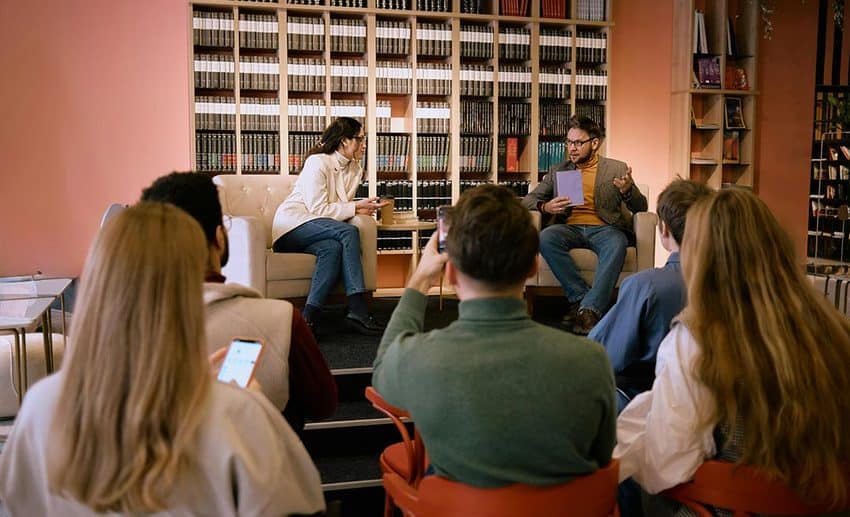 An engaged audience seated inside a room during a book presentation and panel discussion at a literary festival.