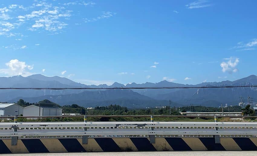 A lush green valley framed by the window of an express bus travelling toward Sokcho.
